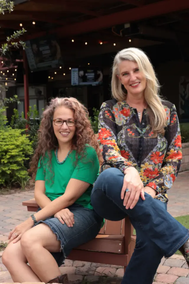 Rachel Miller and Holly Homer sitting together outdoors